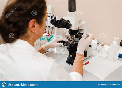 Laboratory Assistant Looks Into Microscope And Makes Blood Test In The