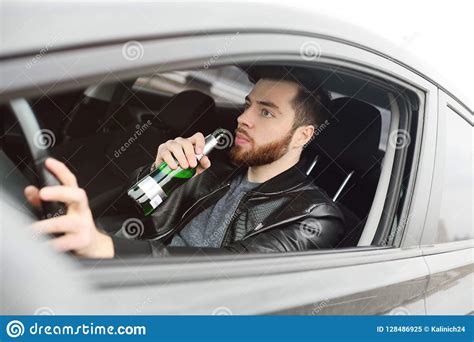 Hombre Con Una Botella De Cerveza Que Conduce Un Coche Imagen De