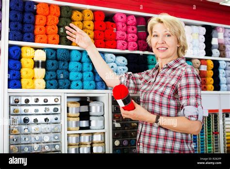 Woman Picking Yarn And Wool Balls For Hobby In Craft Shop Stock Photo