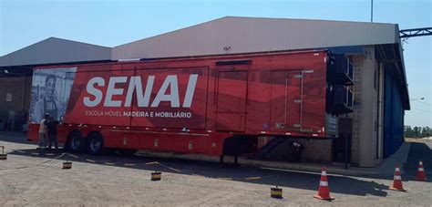 A Red Semi Truck Parked In Front Of A Building With An Advertisement On