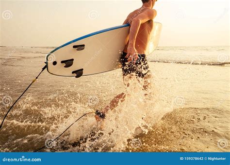 Surfer Man Stands With Surf Board On The Beach Summer Sunset Sea