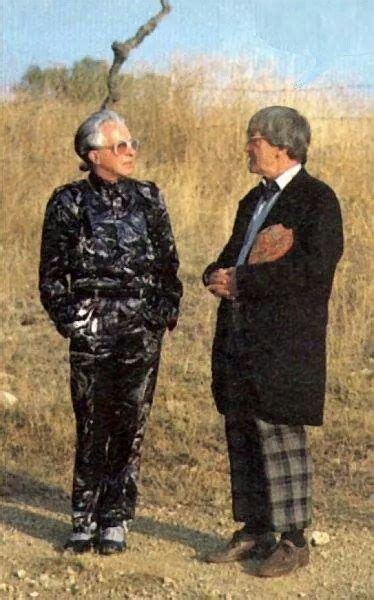 Two Men Standing Next To Each Other In The Grass