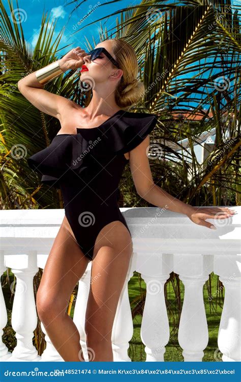 Elegant Woman In The Black Bikini On The Sun Tanned Slim And Shapely