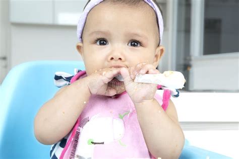 Baby Girl Holding Spoon In Kitchen Stock Image Image Of Looking