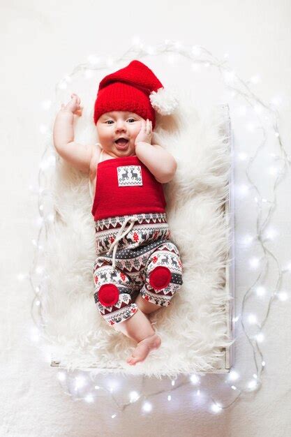 Adorável bebê recém nascido dormindo usando chapéu de Papai Noel Natal