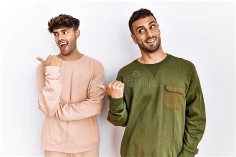 Joven Pareja Gay Parado Sobre Un Aislado Fondo Blanco Sonriendo Con Cara Feliz Y Apuntando Hacia