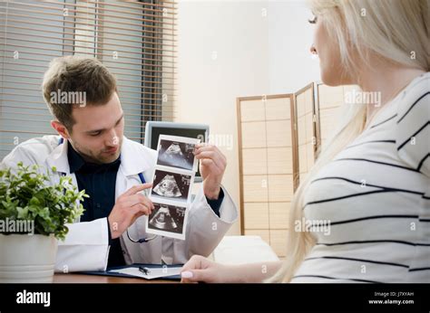 Doctor Showing Baby Ultrasound Image To Pregnant Woman Showing