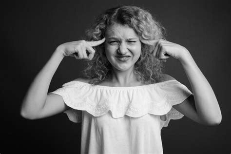 Premium Photo Portrait Of Smiling Girl Standing Against Black Background