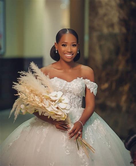 A Woman In A Wedding Dress Holding A Bouquet