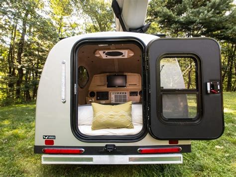 An Open Camper Van Door With The Bed Pulled Out