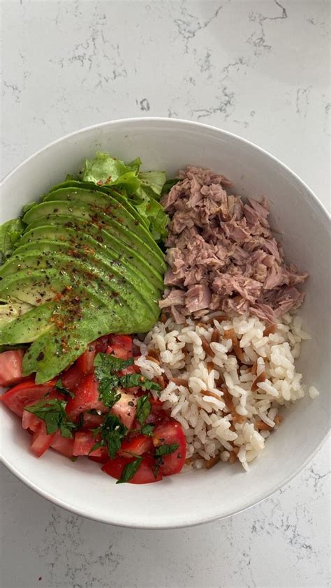 A Bowl Filled With Rice Meat And Veggies On Top Of A Table