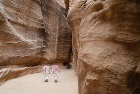 Premium Photo Two Arab Tourists Walk Through The Siq In Petra En