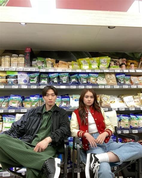 Two People Sitting On Chairs In Front Of A Store Shelf With Food Items