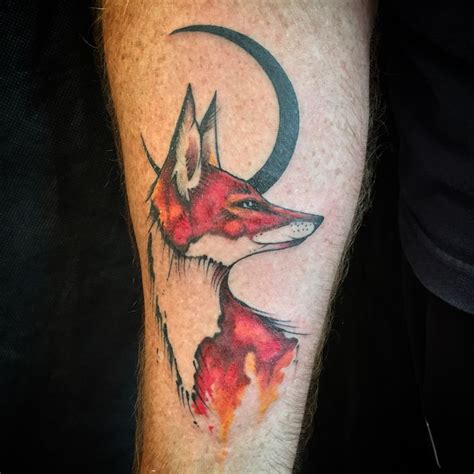 A Man With A Tattoo On His Arm That Has A Fox And Crescent Moon On It