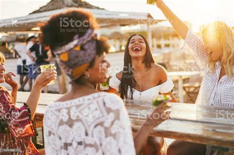 Happy Girls Having Fun Drinking Cocktails At Bar On The Beach Focus On African Girl Face Stock