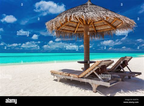 Two Chairs And Umbrella On A Tropical Beach With Amazing Lagoon View