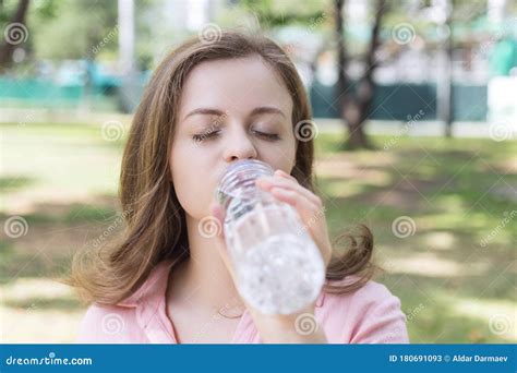 Eau Potable De Jeune Fille Du Caucase De Femme Dune Bouteille En Plastique Dans La Fin Verte Du