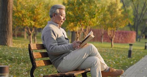 Senior Chinese Man Reading Book In The Park K High Res Stock Video For