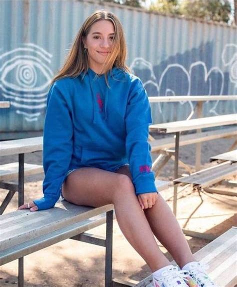 A Woman Sitting On Top Of A Wooden Bench