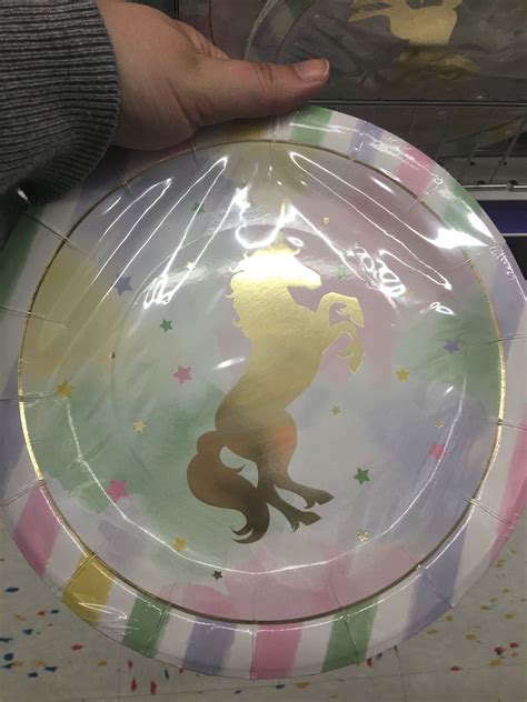 A Person Holding A Paper Plate With A Design On It In Front Of Some Confetti