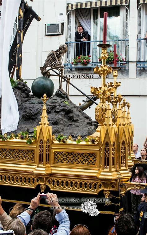 A Large Float Is Being Carried Down The Street With People Taking