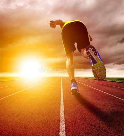 Athletic Young Man Running On Race Track With Sunset Background Stock