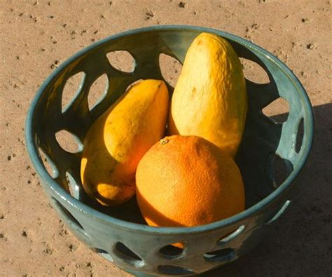 a blue bowl filled with oranges and lemons