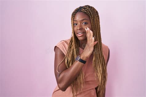 Mujer Afroamericana Con El Pelo Trenzado Sobre La Mano De Fondo Rosado