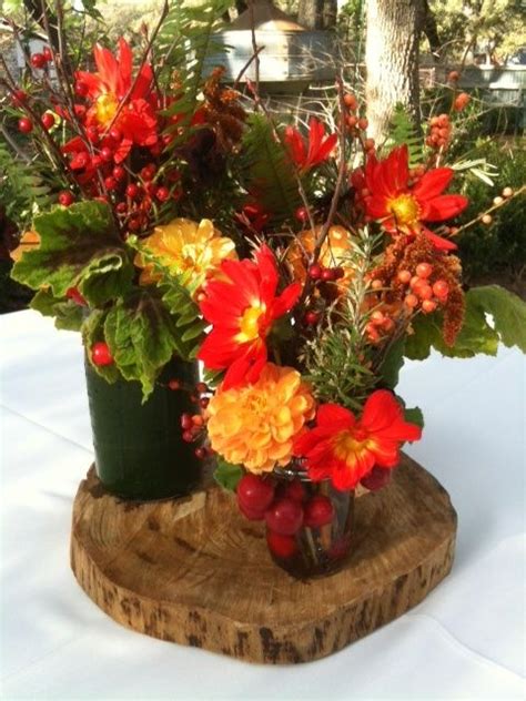 A Vase Filled With Flowers Sitting On Top Of A Wooden Slab Next To A Tree