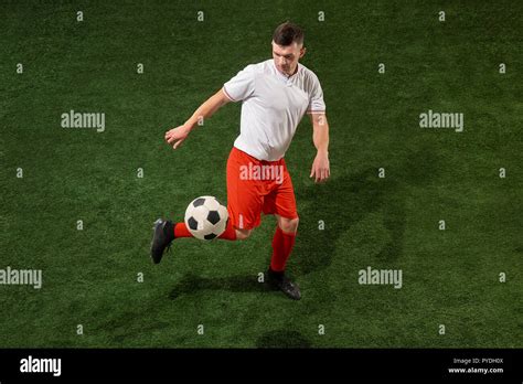 Football Player Tackling For Ball Over Green Grass Background