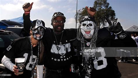 Oakland Raider fans in costumes pose during tailgate festivities before ...