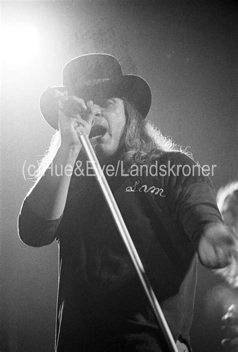 A Black And White Photo Of A Man Singing Into A Microphone