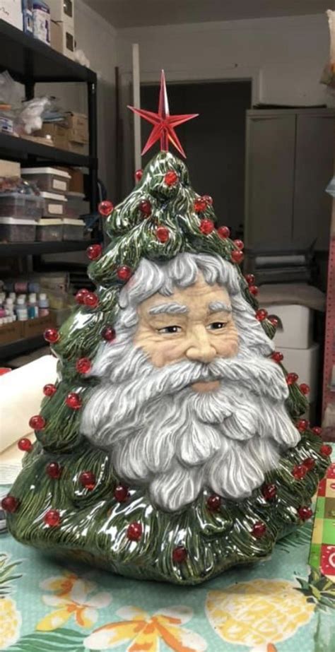 A Ceramic Christmas Tree With A Santa Claus Face