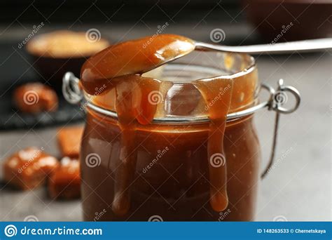 Jar With Tasty Caramel Sauce And Spoon On Table Stock Image Image Of