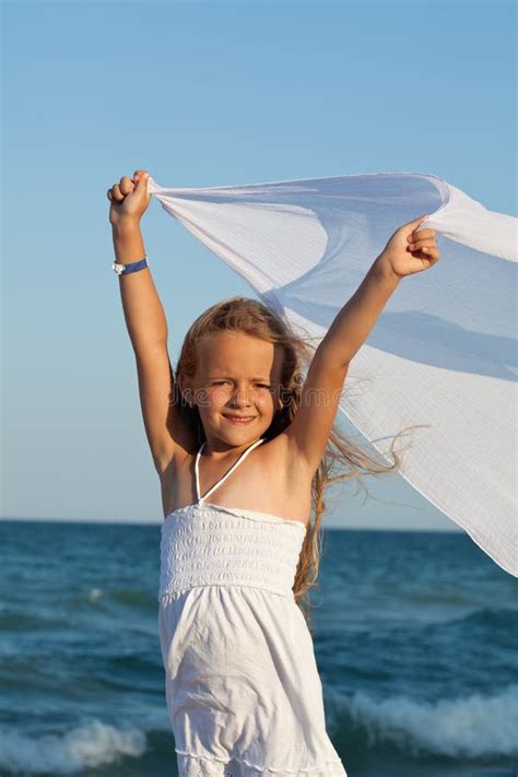 Petite Fille Sur Le Bord De Mer Jouant Avec Un Foulard Dans Le Vent