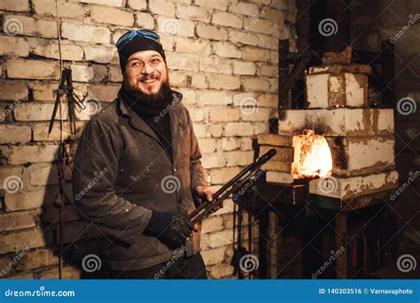 Bearded Man Blacksmith Gets A Red Hot Billet Out Of The Furnace Stock Photo Image Of Fire