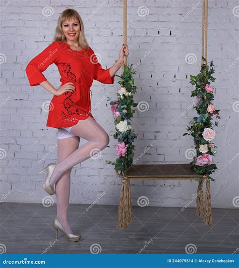 Belle Fille Blonde à Long Pattes En Minidress Rouge Et Des Bas Blancs