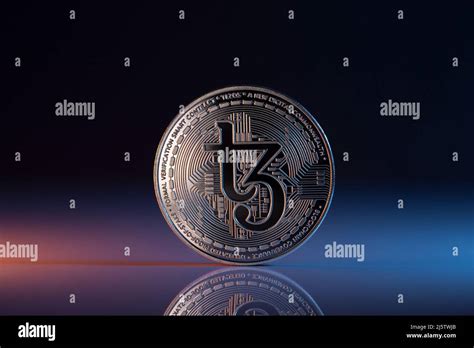 Tezos XTZ Cryptocurrency Physical Coin placed on reflective surface and ...