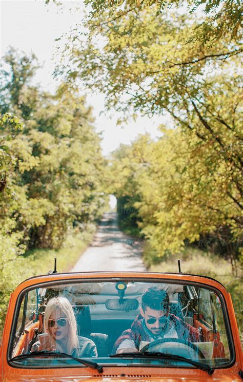 Woman Looks At Phone And A Man Holds A Map In The Car Del Colaborador De Stocksy Alexandra