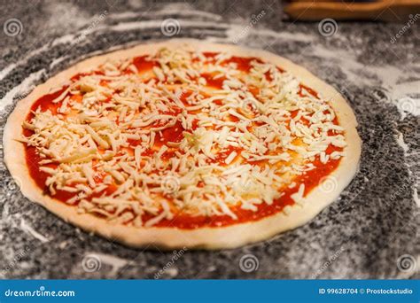 Raw Pizza With Tomato Sauce And Grated Cheese Stock Photo Image Of