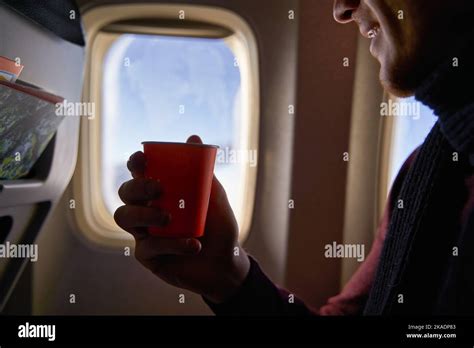 Smiling Airline Passenger With A Paper Cup Of Coffee Looking Ahead In
