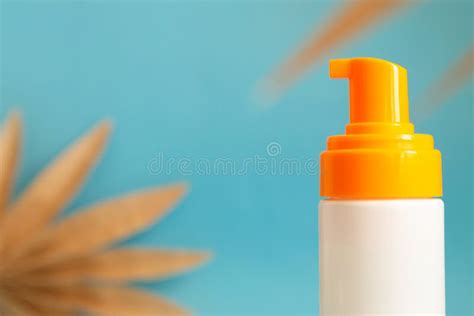 White And Yellow Sunscreen Bottle With Cream Or Lotion On The Aqua Blue