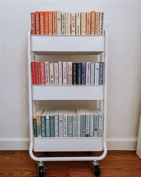 There Is A Book Shelf With Many Books On It In Front Of A White Wall