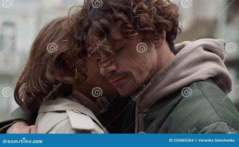 Affectionate Couple Hugging Outside Man Putting Head On Woman Shoulder