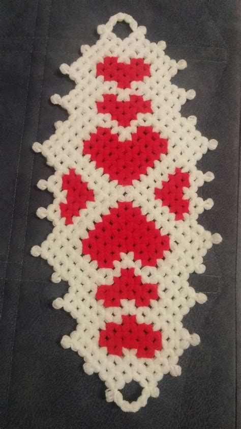 A Piece Of Art Made Out Of White And Red Beads On A Black Surface With