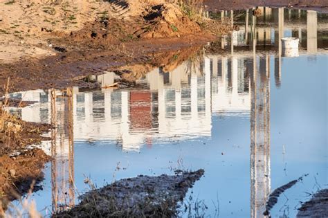 Uma grande poça após a chuva no canteiro de obras de um grande edifício