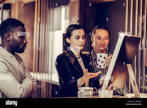 Serious Brunette Girl Pointing At Screen Of Computer Stock Photo Alamy