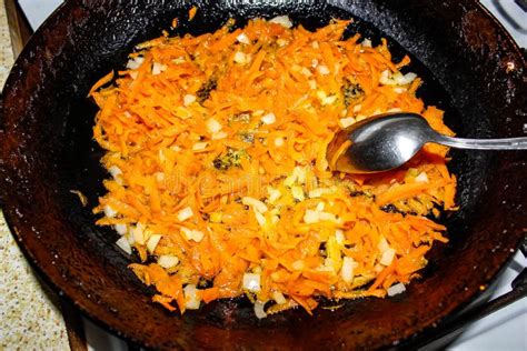 Frying Carrots With Onions And Stewed Meat In Cauldron Stock Photo