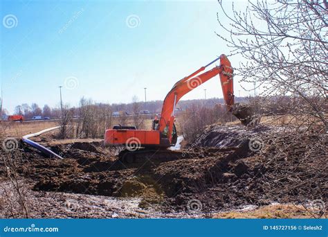 Construction Equipment Digging A Hole Orange Excavator Running In The