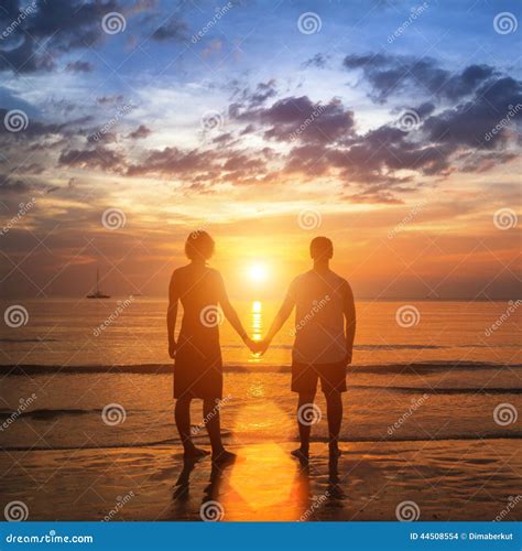 Teenage Couple Holding Hands In The Sunset